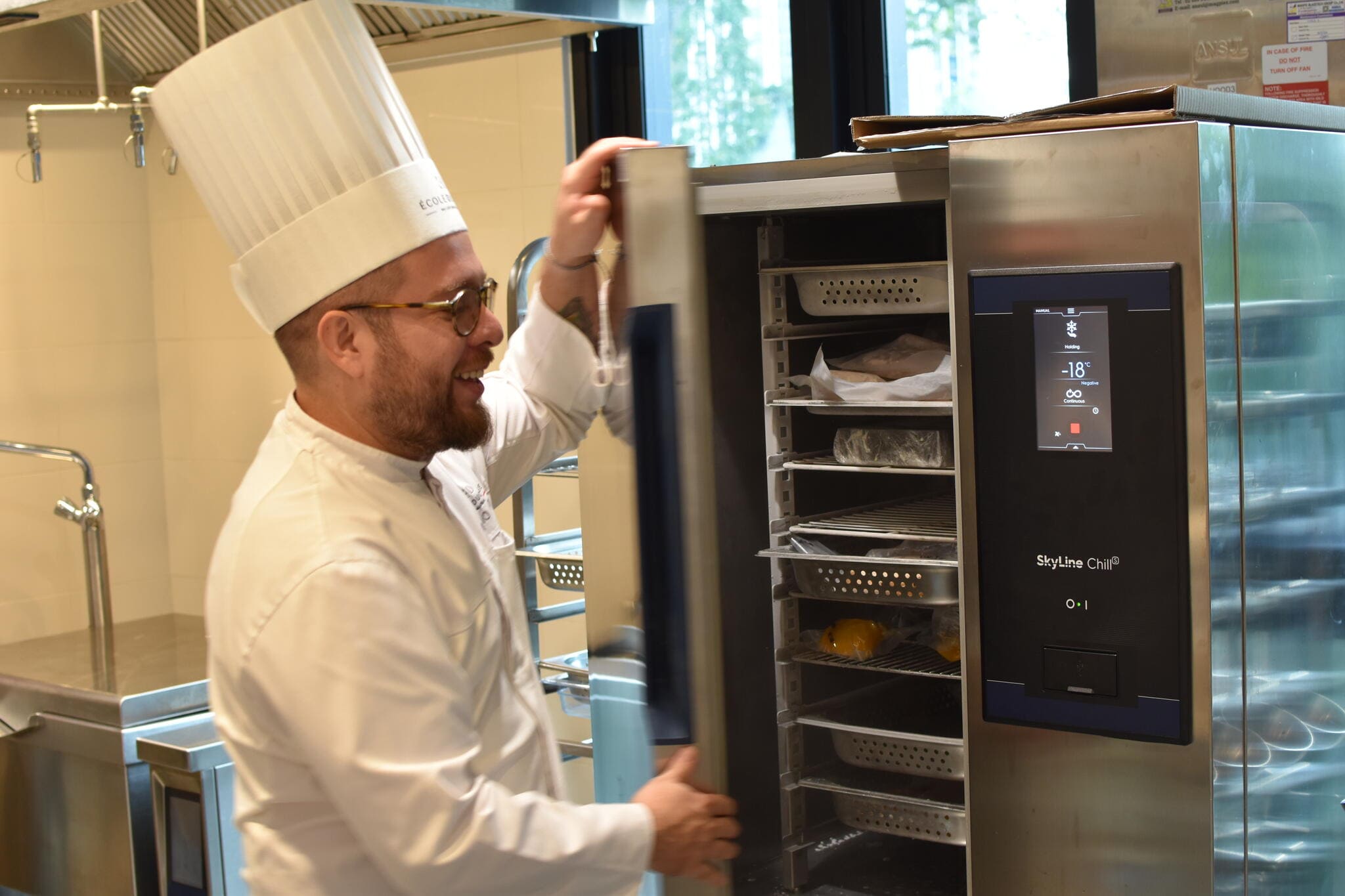 Chef in full uniform using Electrolux Professional oven at École Ducasse Bangkok Studio professional kitchen