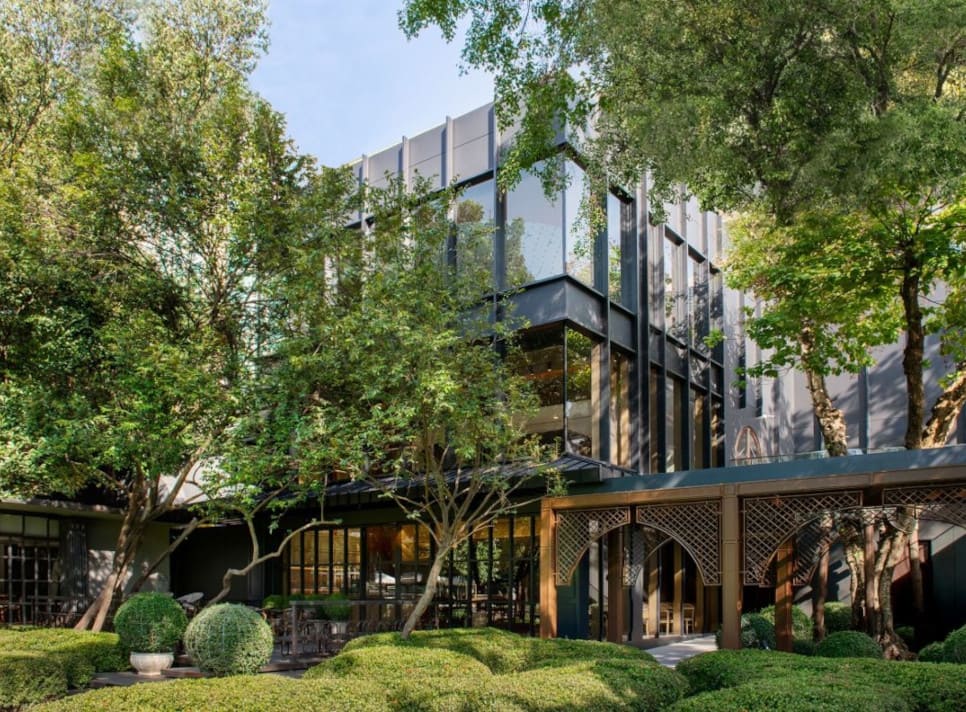Modern exterior of École Ducasse Nai Lert Bangkok Studio surrounded by trees and gardens