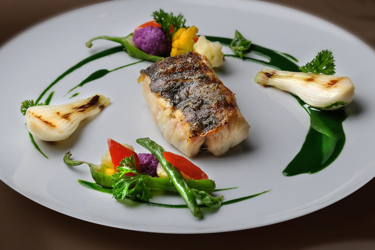 Elegant plated fish dish with vegetables served at Grand Hotel Excelsior Vittoria fine dining restaurant