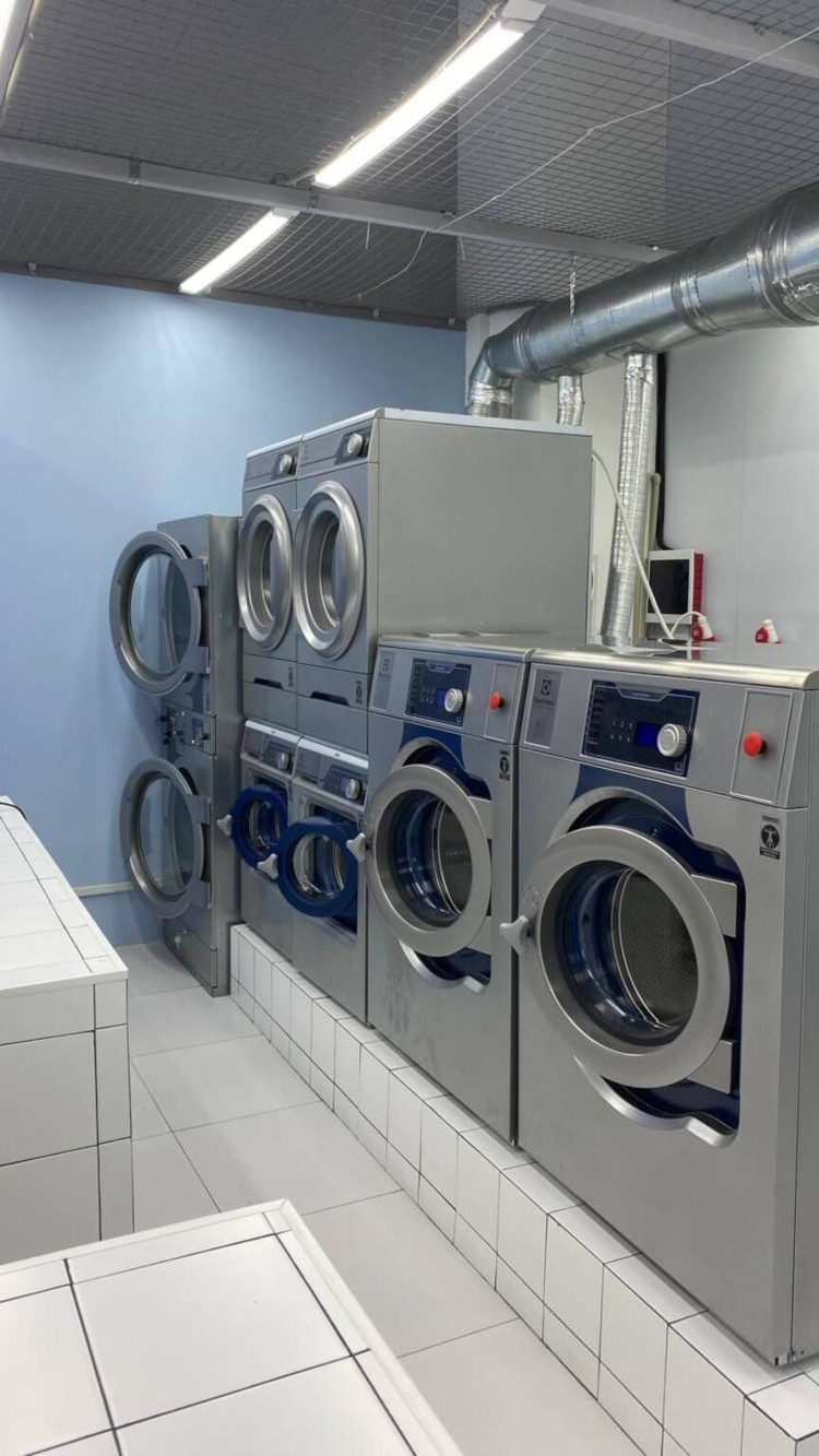Row of Electrolux Professional washing machines and dryers at Mamalama laundry facility