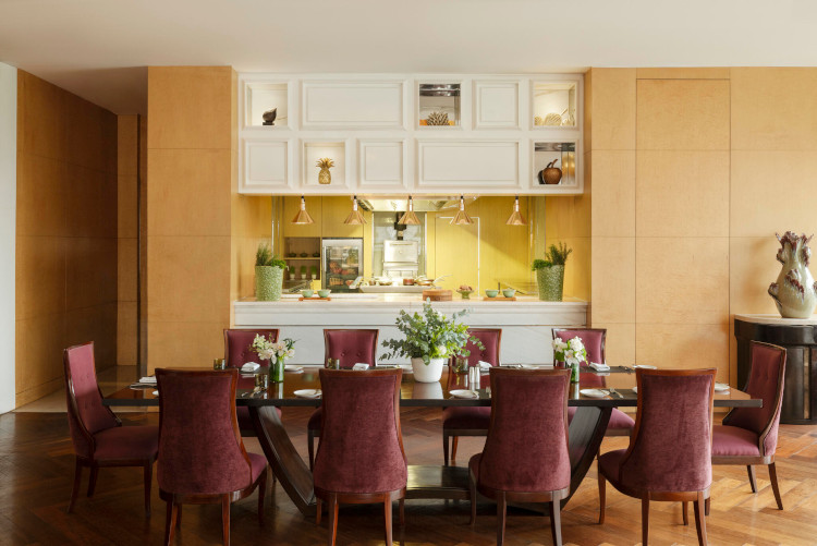 Dining room with set table and open kitchen view at Raffles Hotel Jakarta fine dining restaurant