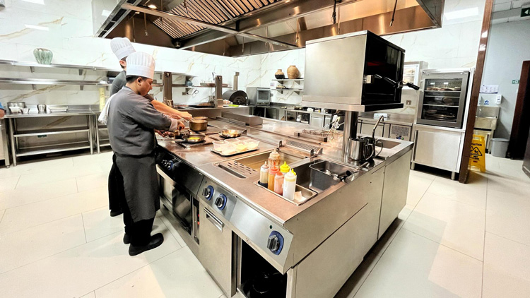 Chef preparing gourmet dishes on Electrolux Professional cooking range at Raffles Hotel Jakarta