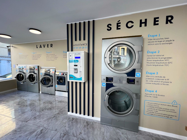 Electrolux Professional self-service dryer installed at St Omer Laundromat with wall instructions