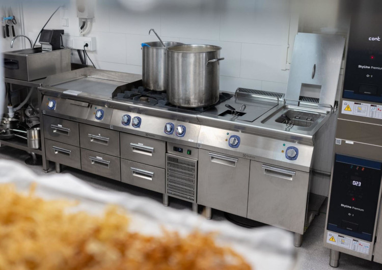 Stainless steel Electrolux Professional cooking range with pots in hotel resort professional kitchen