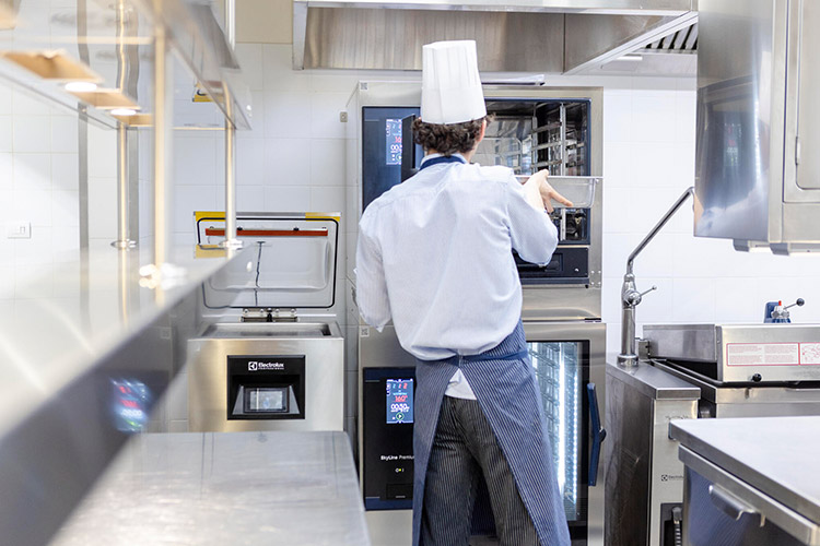 Chef operating Electrolux Professional combi oven in luxury hotel professional kitchen