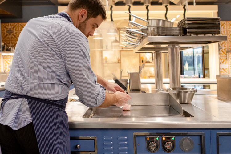 Professional cooking station with working chef, equipped with Molteni equipment